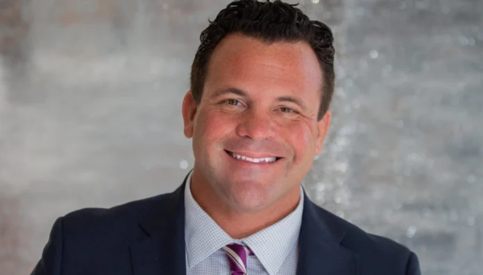 John Cerasani net worth profile image featuring the entrepreneur speaking at a business event, symbolizing his rise from insurance founder to venture capitalist.